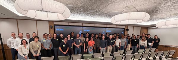 The Thrive Holdings team gathered in a conference room beneath screens reading HOLDINGS