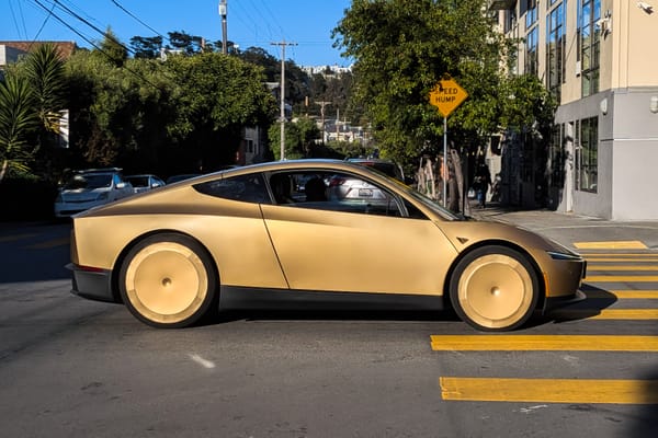 Tesla Cybercab two-seat robotaxi parked on a street, showing a vehicle with no steering wheel, pedals or mirrors