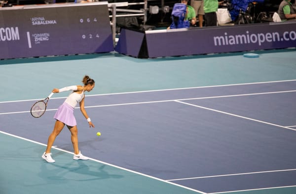 Zheng Qinwen serving during a match at the 2025 Miami Open